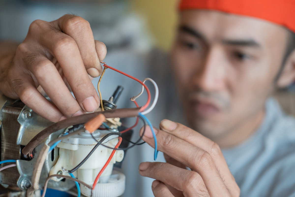 Close up of Asian Electronics Repairman Fixing Broken Wires